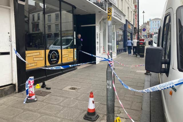 Forensic teams at the scene outside a restaurant on Newborough where a man was attacked.
