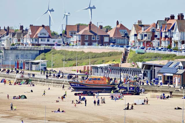 Aled Jones frames Bridlington's lifeboat amongst visitors on the beach.