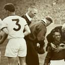 Training staff help the injured Manchester United keeper Ray Wood - referee Frank Coultas is second left.