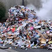 Firefighters douse the smouldering recycling waste from the bin lorry.