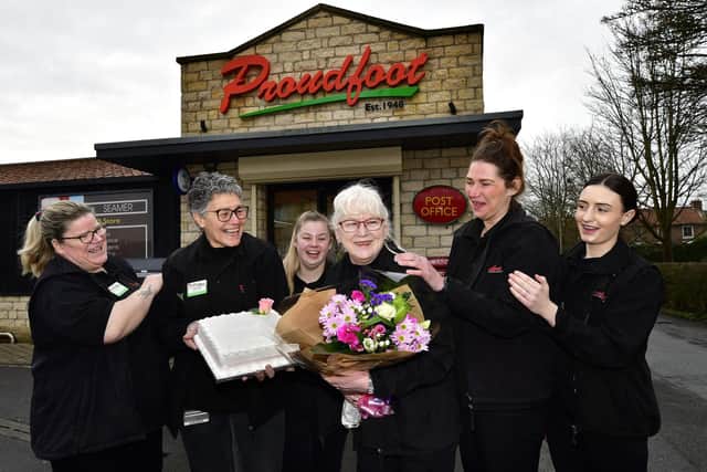 Staff present present Miss Wilson with a cake and flowers to wish her luck