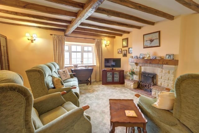 The beamed lounge of the property, with feature fireplace and cosy stove.