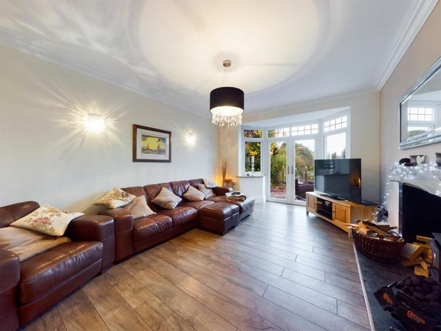 The lounge with bay window and French doors leading outside, also has a warming log burner.