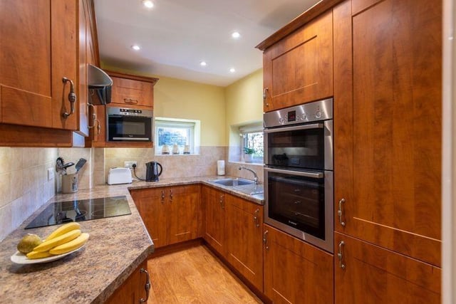 The cottage kitchen has fitted units with integrated appliances.