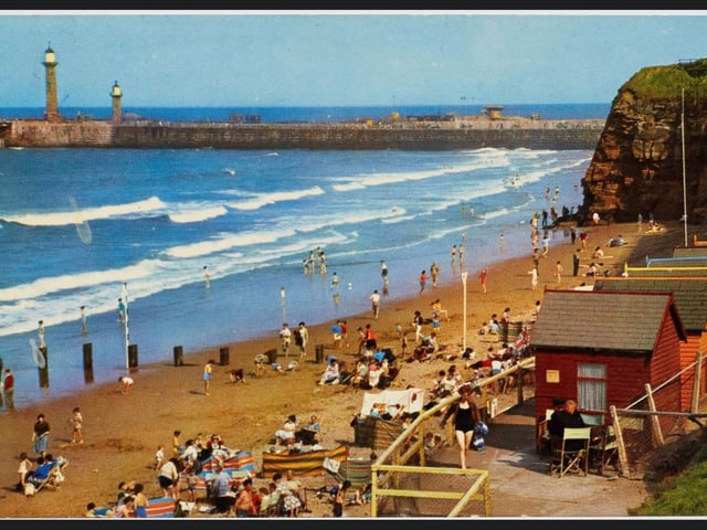 A colour postcard showing the beach at Whitby, circa 1960s to 1970s.