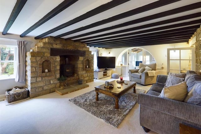 A log burner within a large stone fireplace feature is a focal point of this lounge.