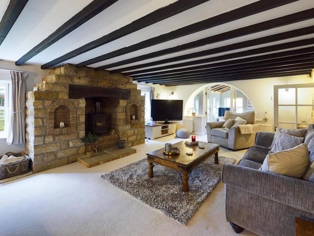 A log burner within a large stone fireplace feature is a focal point of this lounge.