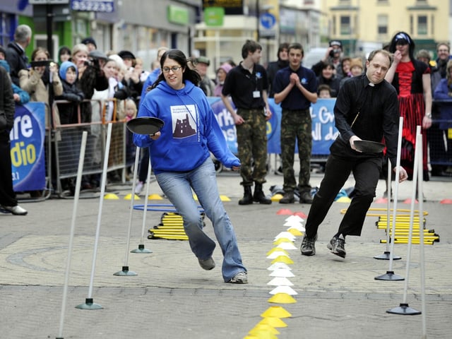 Maya Richardson, left, from the Scarborough Hospital Friends taking part in the town centre pancake races fun competition - 12/02/2013