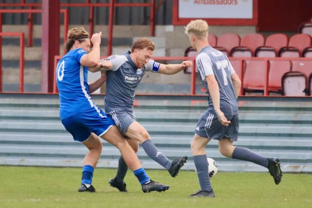 Bridlington Rovers Millau (grey kit) get stuck in against North Cave in the East Riding FA Senior Country Cup final at Queensgate. Photo by TCF Photography
