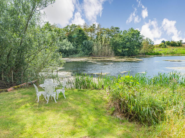 The grounds include this lovely lake, with countryside stretching out beyond.