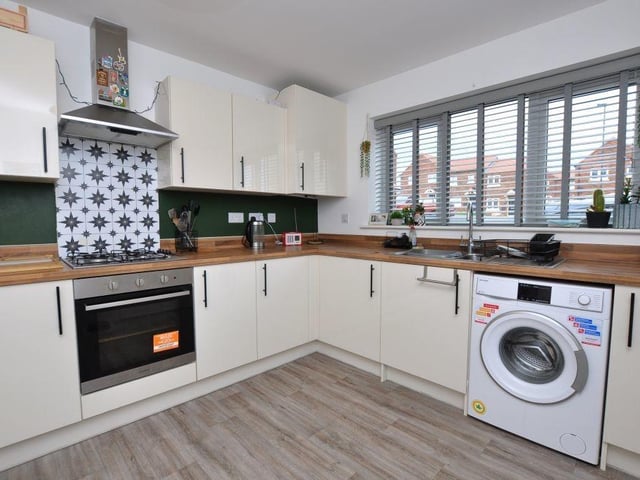 This well-equipped kitchen has integrated appliances, and space for a dining table and chairs.