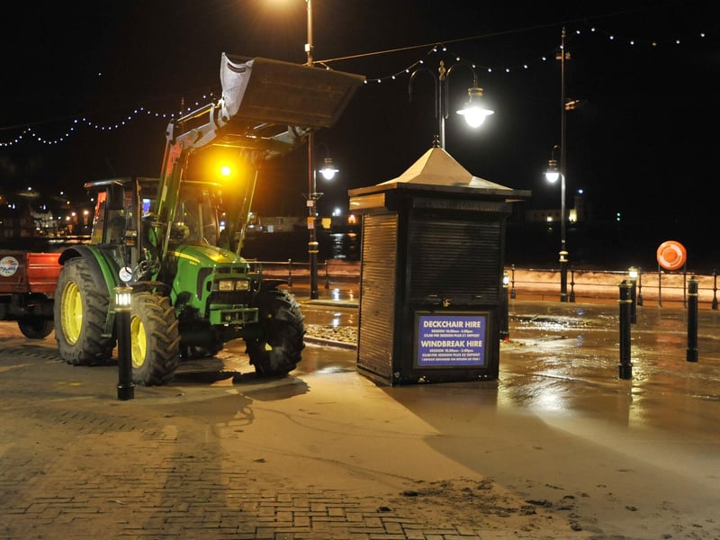 The high tide recedes leaving huge lumps of rock and concrete on the carriageway and deckchair huts thrown all over in Scarborough.