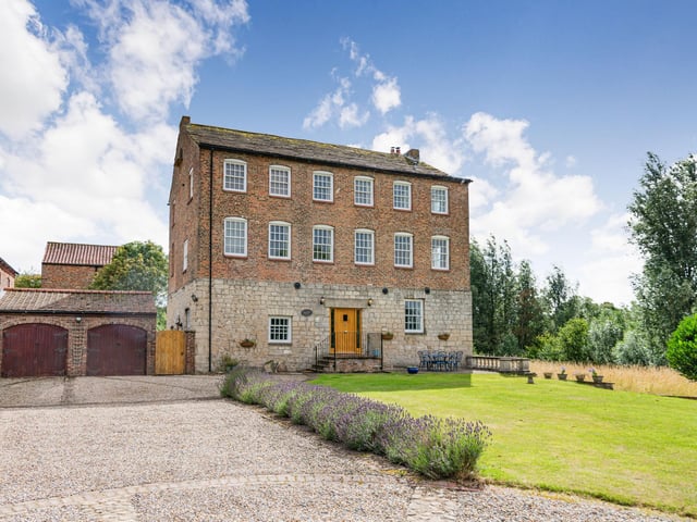 There is a lawned front garden, with a driveway leading to the garages and providing parking space.