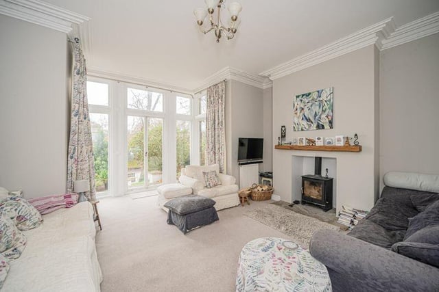 A spacious sitting room with French doors leading outside.