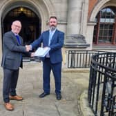 Chris Hall, from SHOUT, hands the petition to Daniel Harry, North Yorkshire Council's head of democratic services.