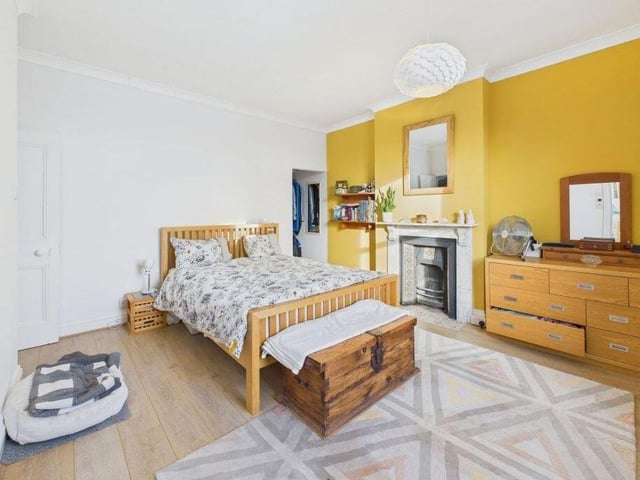 This bedroom, one of five in the property, has a feature fireplace.