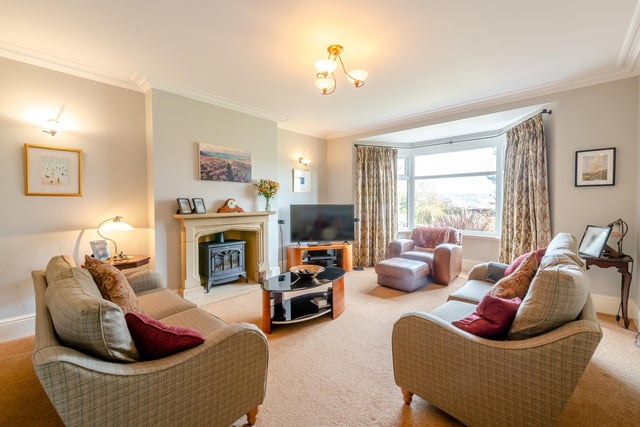 A bay-fronted sitting room with feature fireplace.