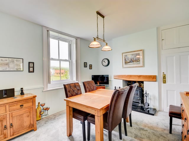 The dining room, with stove feature, has space for a larger style suite.