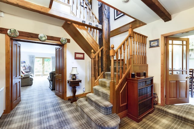 The carpeted hallway with ceiling beams opens through to ground floor rooms.