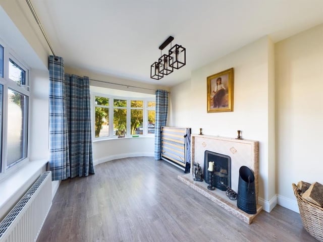 The dining room with feature fireplace is flooded with light from its large windows.