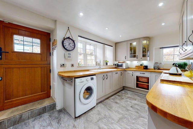 The bright kitchen with fitted units and integrated appliances has a stable door to outside.