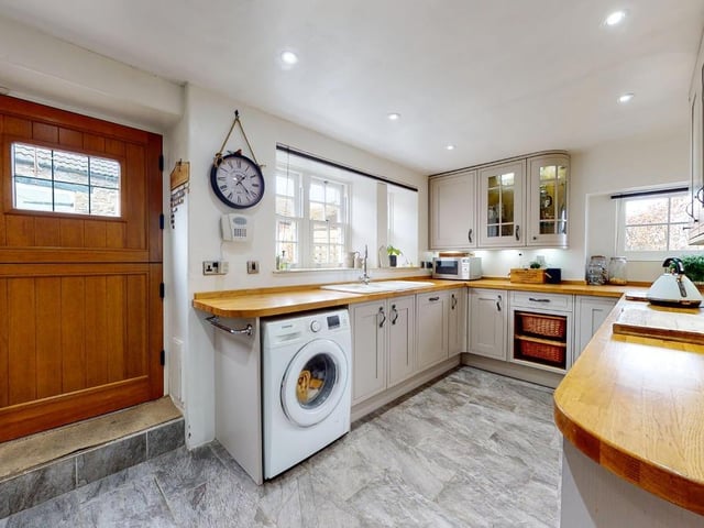The bright kitchen with fitted units and integrated appliances has a stable door to outside.
