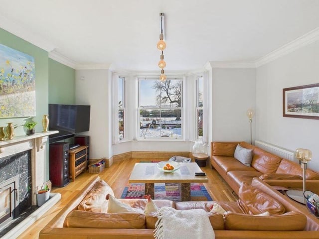 A bay fronted, spacious lounge with feature fireplace has stunning views over the garden and beyond.