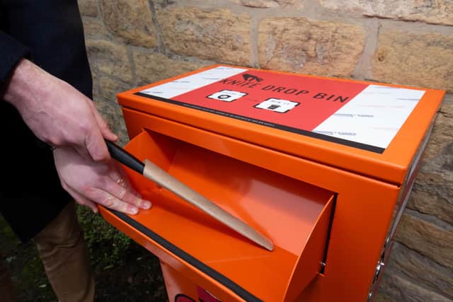 A knife is safely deposited in a knife bin.