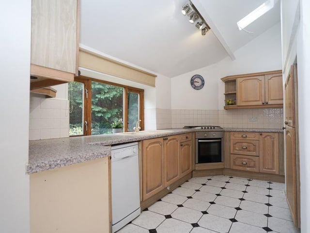 The kitchen with fitted units and garden views.