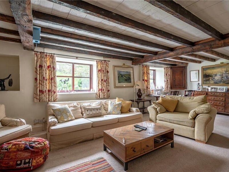 A spacious reception room with beams to the ceiling.