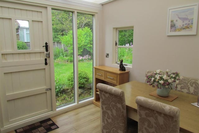 The dining room has views of the side garden, and a door leading outside.