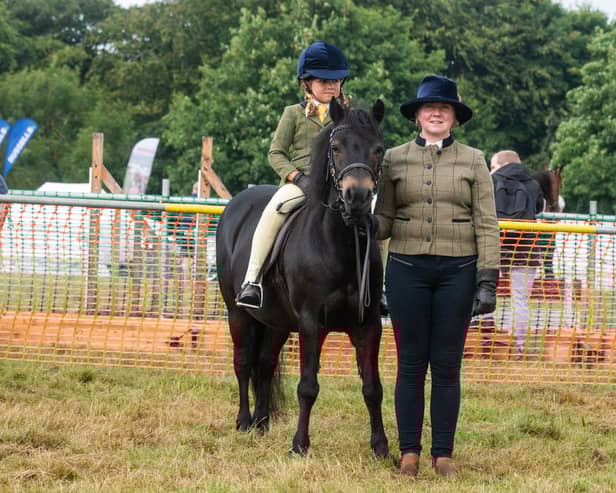Isabelle Bunyan, of Egton, riding Cayberry Stringfellows, held by her mum Louise Bunyan, at the 2022 Egton Show.