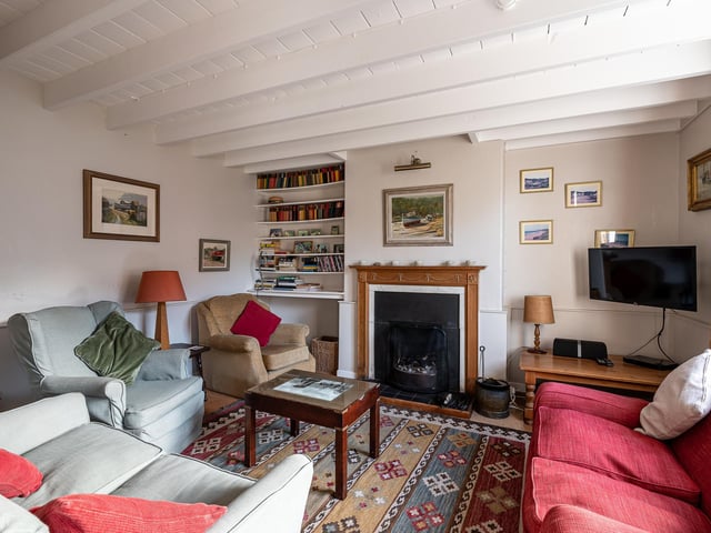 A central fireplace is a focal point of this comfortable room, that has inbuilt shelving.