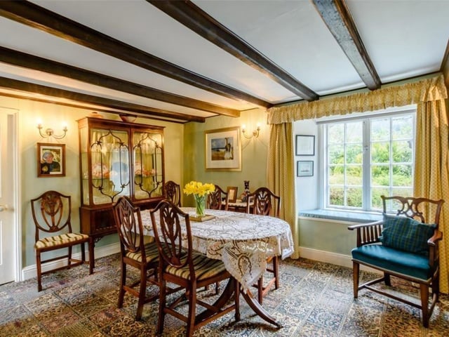 The beamed dining room has a window seat with views of the garden.