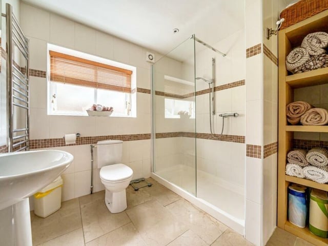 A bathroom with modern, walk-in shower unit.