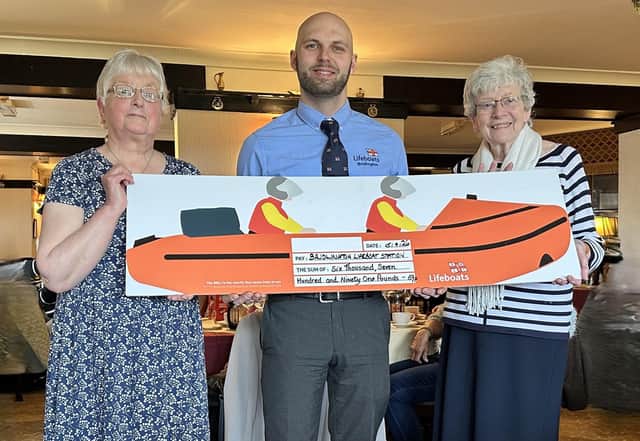 Anne Saunders (outgoing chair) and Pat Lammas (president) present a cheque to Bridlington Lifeboat volunteer Aleksandrs Lurans.