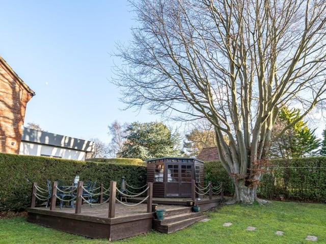 The rear garden has a summer house and decked seating area.