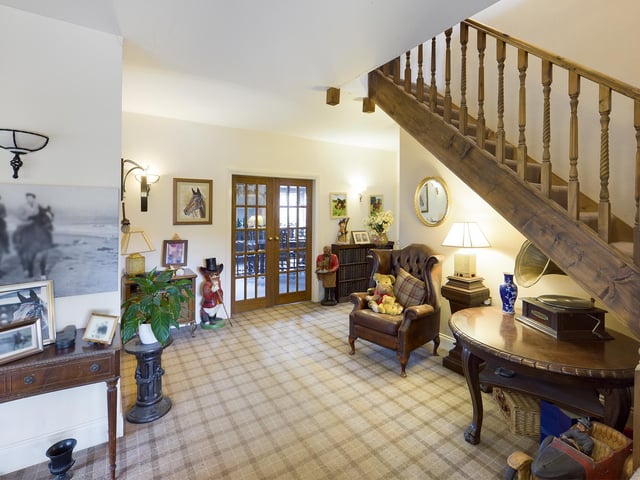 The roomy hallway with staircase leading up has doorways to several ground floor rooms.