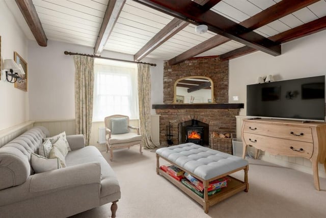 A cosy beamed sitting room with feature fireplace.