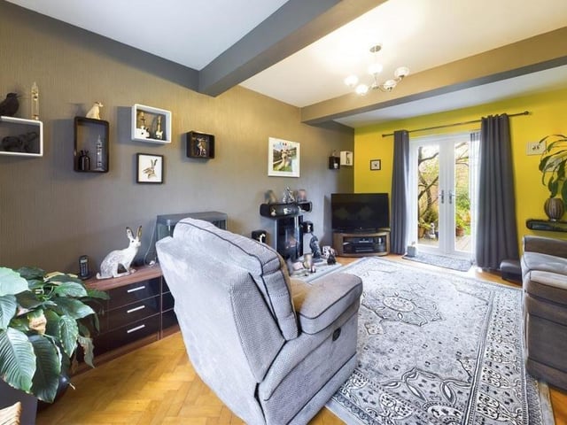 A beamed lounge with parquet flooring, and double glazed French doors out to the patio and garden.