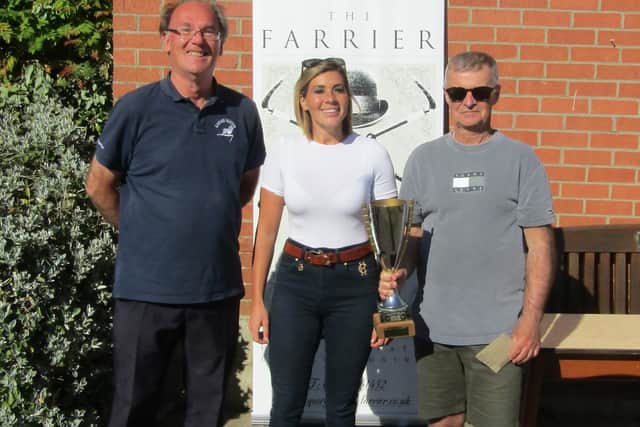 Winners Robert Child, left, and Ian Richardson collect the trophy from Danielle Bushby, from The Farrier.