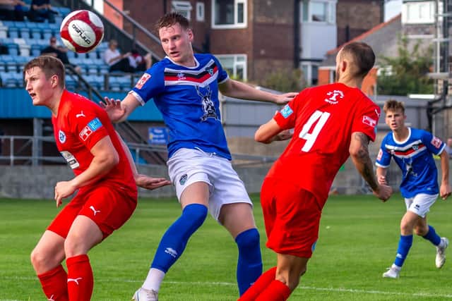 Whitby's Jerome Greaves battles for the ball against Rylands.