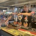 Claudia Bowes, Scarborough News reporter, being handed the old purse from Tara Giles, owner of the Belle Vue pub, on behalf of her mother.