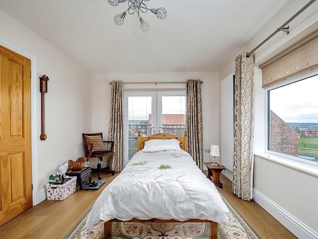 A spacious bedroom with large windows and patio doors leading outside.