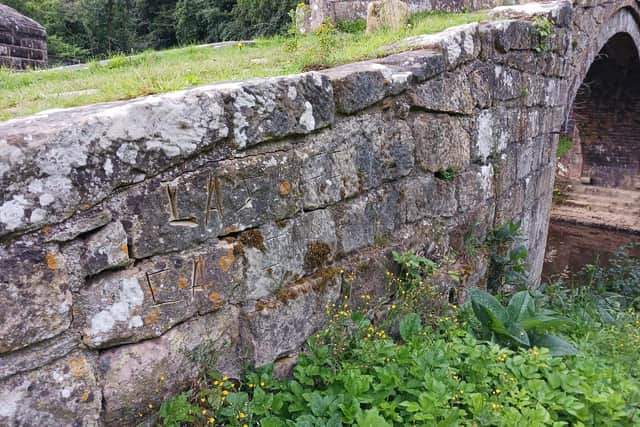Letters inscribed into the stonework on 400-year-old Beggars Bridge.
