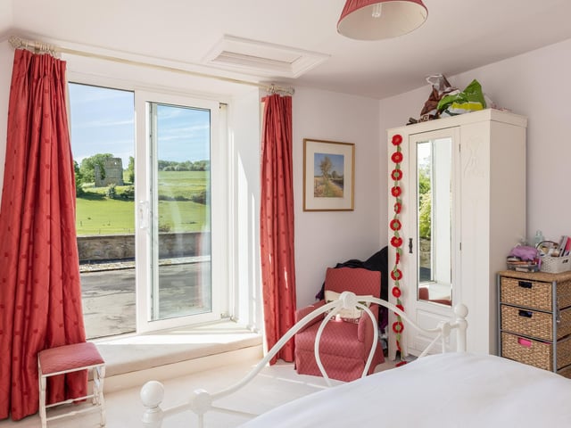 Doors lead out to a terrace from this cottage bedroom.