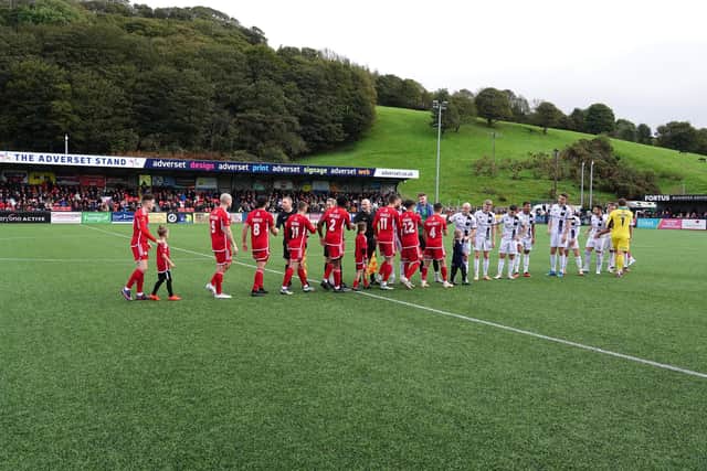 The two sets of players shake hands before the kick-off.