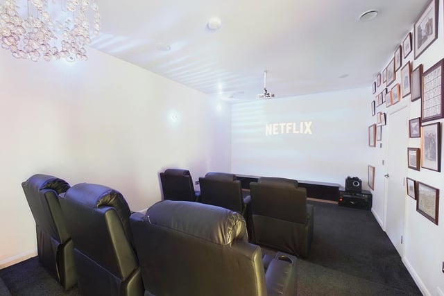 A cinema room with reclining chairs.