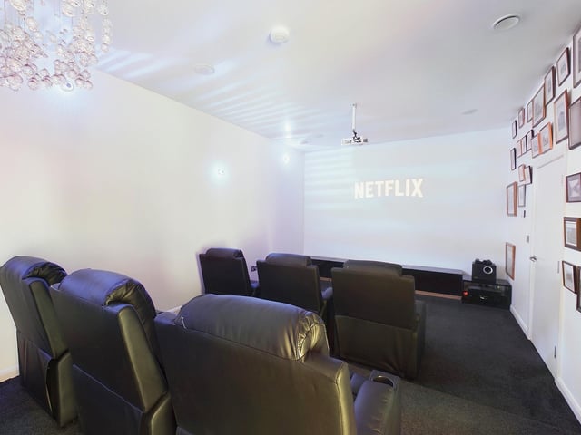 A cinema room with reclining chairs.