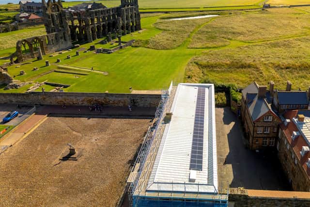 Image showing solar panels on the roof of the visitor centre, with Whitby Abbey behind.